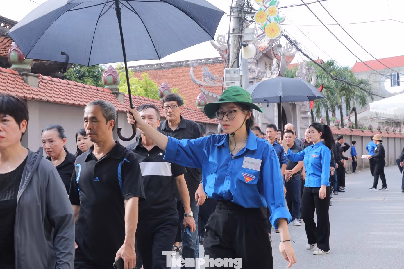 Trong ngày đầu lễ tang, thời tiết oi bức, lúc nắng, lúc mưa nhưng những bóng áo xanh vẫn tích cực hỗ trợ người dân.