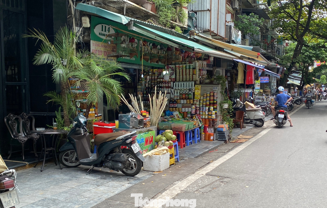 Hàng hoá bày bán chắn hết lối đi trên vỉa hè tại phố Hàng Buồm.