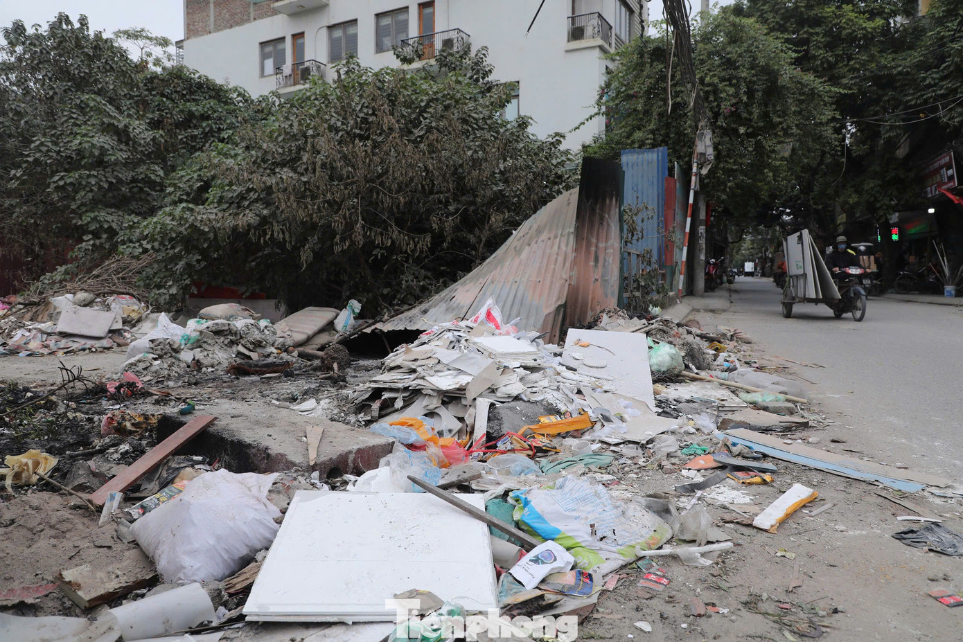 Rác thải đủ các loại đổ tràn cả xuống lòng đường, tiềm ẩn mất an toàn giao thông.