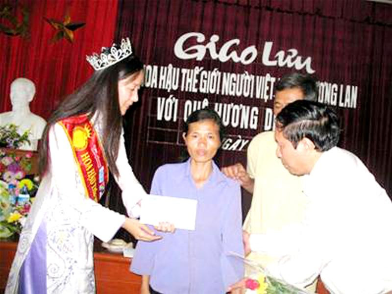 Hoa hậu Ngô Phương Lan và Tổng biên tập Dương Xuân Nam tặng quà cho nạn nhân chất độc màu da cam. Ảnh: Quang Long.