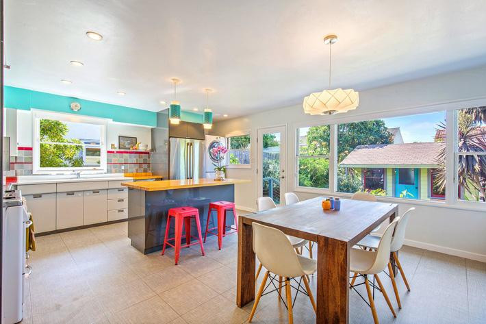 Hệ thống cửa sổ khổ lớn bằng kính được phân bố khắp nhà, nhất là khu vực bếp để tạo không gian mở, nhìn ra khu vườn nhiều cây cối bên ngoài.