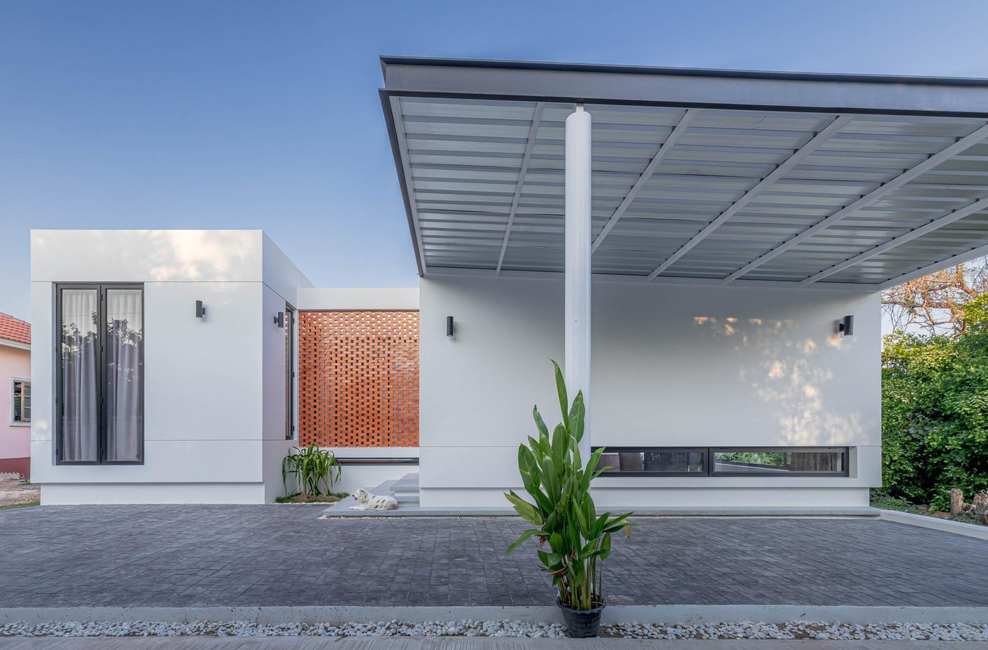 Cấu trúc ngôi nhà được làm theo dạng nhà cấp 4 mái bằng hình chữ U. Phần sân phía trước nhà lát đá đen và có mái che cho ô tô.