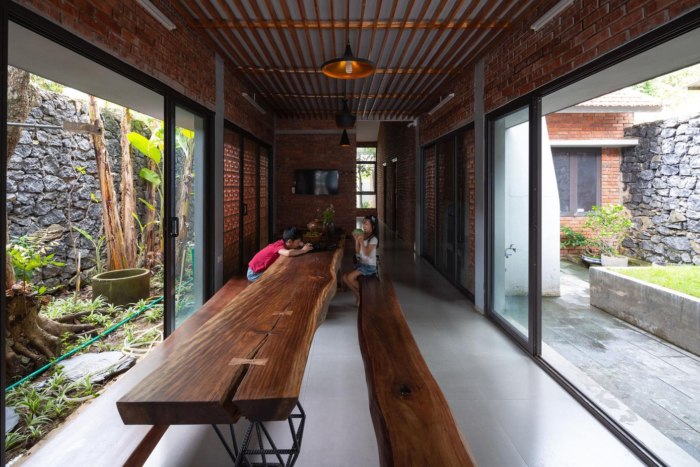 Khu bàn ăn và vui chơi của trẻ em được đặt ở trung tâm ngôi nhà. Phía sau khu vui chơi là khu vực phòng ngủ.