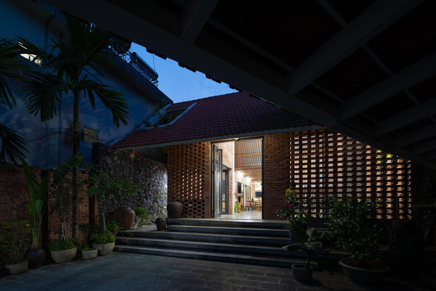 Ở mặt tiền, sau lớp gạch đỏ là lớp cửa kính trong suốt để ánh sáng và tầm nhìn không bị giới hạn.