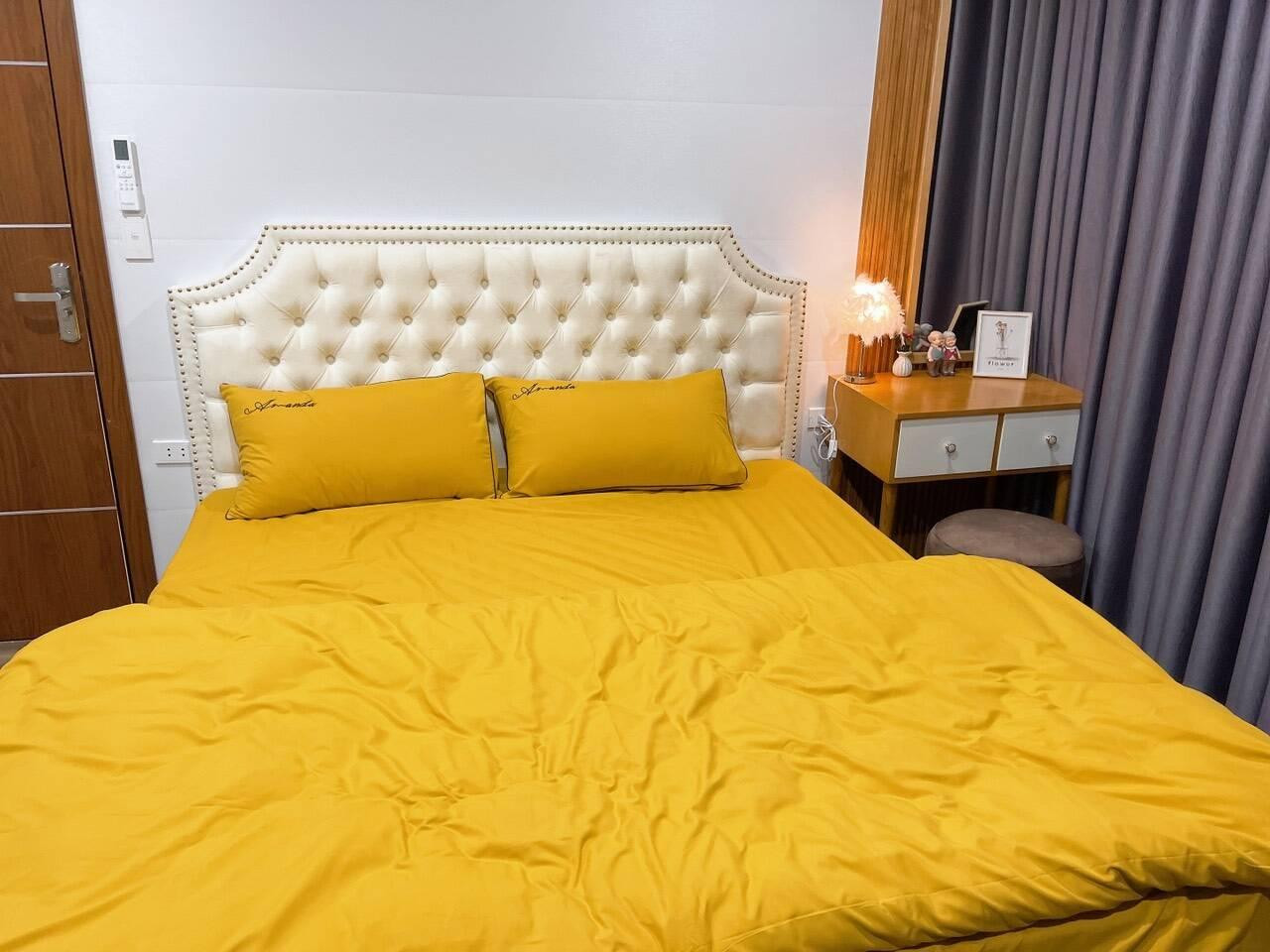 Phòng ngủ còn lại trải bộ ga màu vàng nổi bật bắt mắt.