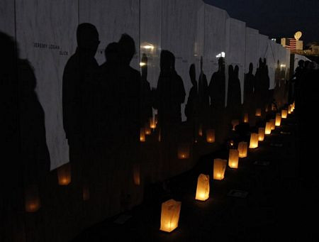 Những cây nến cạnh bức tường khắc tên các nạn nhân