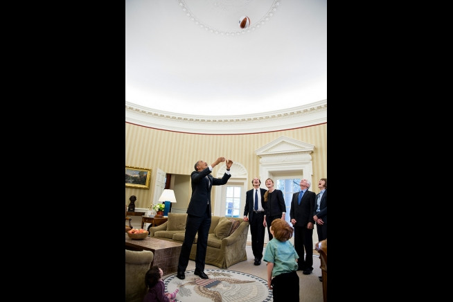 Ngay cả trong phòng làm việc, tổng thống Obama vẫn ném bóng bầu dục đùa cùng với thành viên chính phủ và một cậu bé