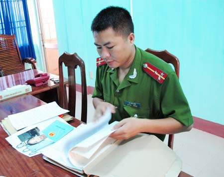 Thượng úy Lê Minh Vân bên hồ sơ đối tượng bị truy nã