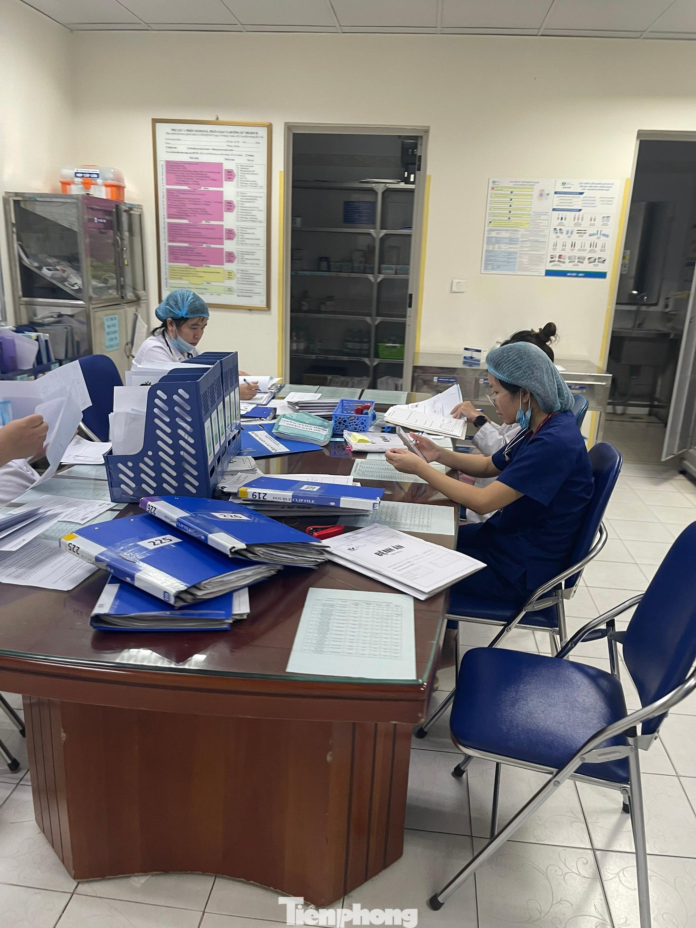 Bác sĩ, điều dưỡng xử lí những tập bệnh án dày cộp của bệnh nhân. Ảnh: Thái Hà