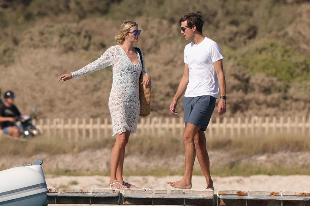 Ái nữ nhà Trump mặc chiếc váy đan móc màu trắng của TruCulture, có giá 72 USD. Cô hoàn thiện vẻ ngoài đậm chất mùa hè với kính râm tráng gương, túi rơm &quot;đựng cả thế giới&quot; và sandal bệt màu trắng.