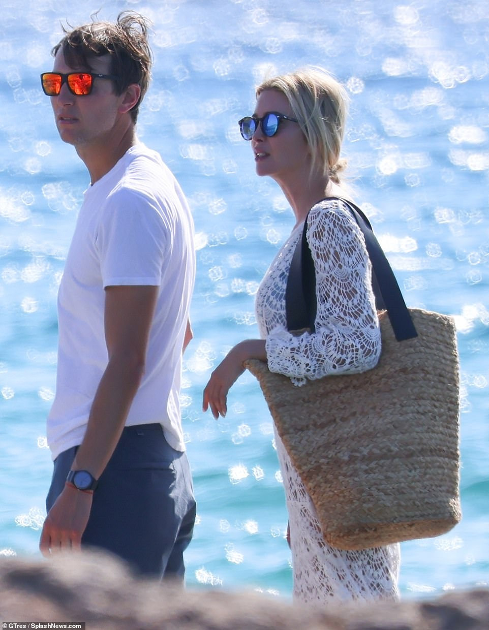 Jared Kushner giản dị hơn với áo phông trắng, quần đùi xanh đậm, kính mắt tráng gương và dép tông.