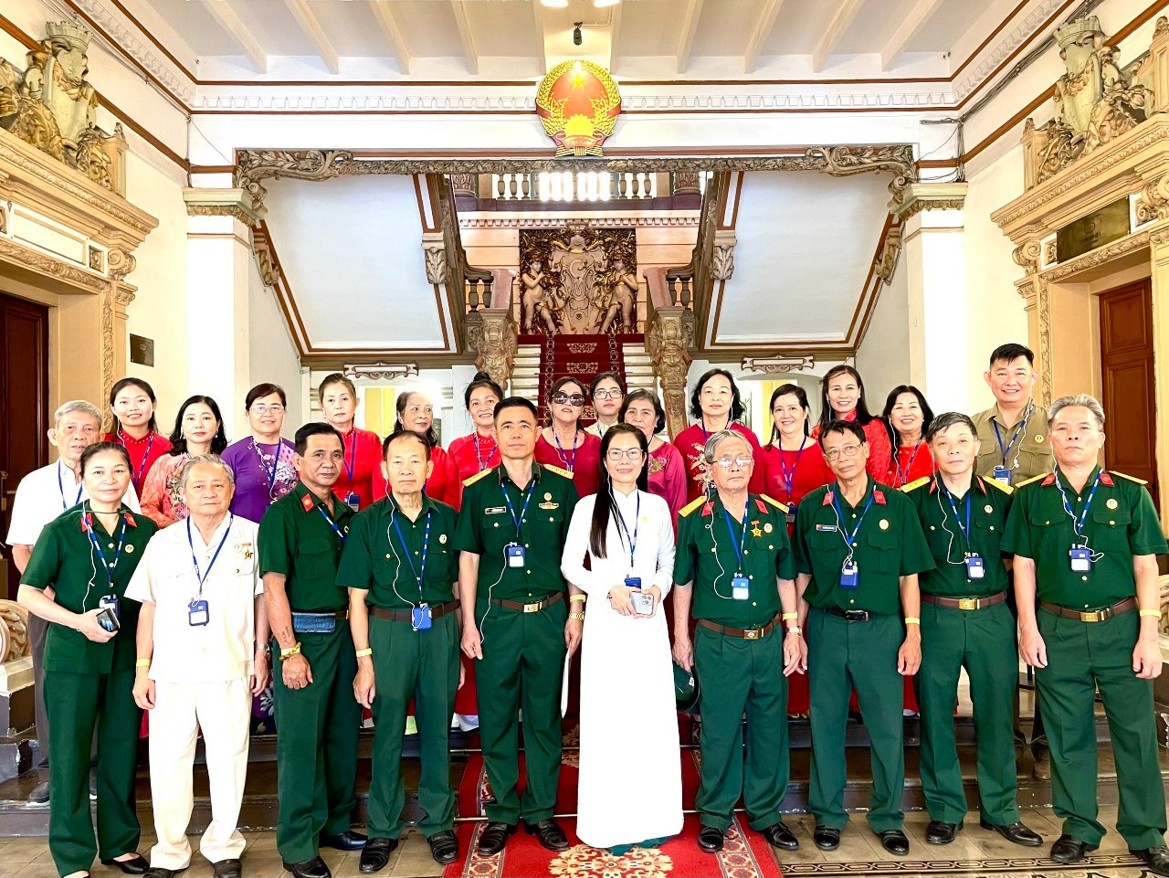 Đoàn khách cựu chiến binh chụp hình lưu niệm sau khi tham quan