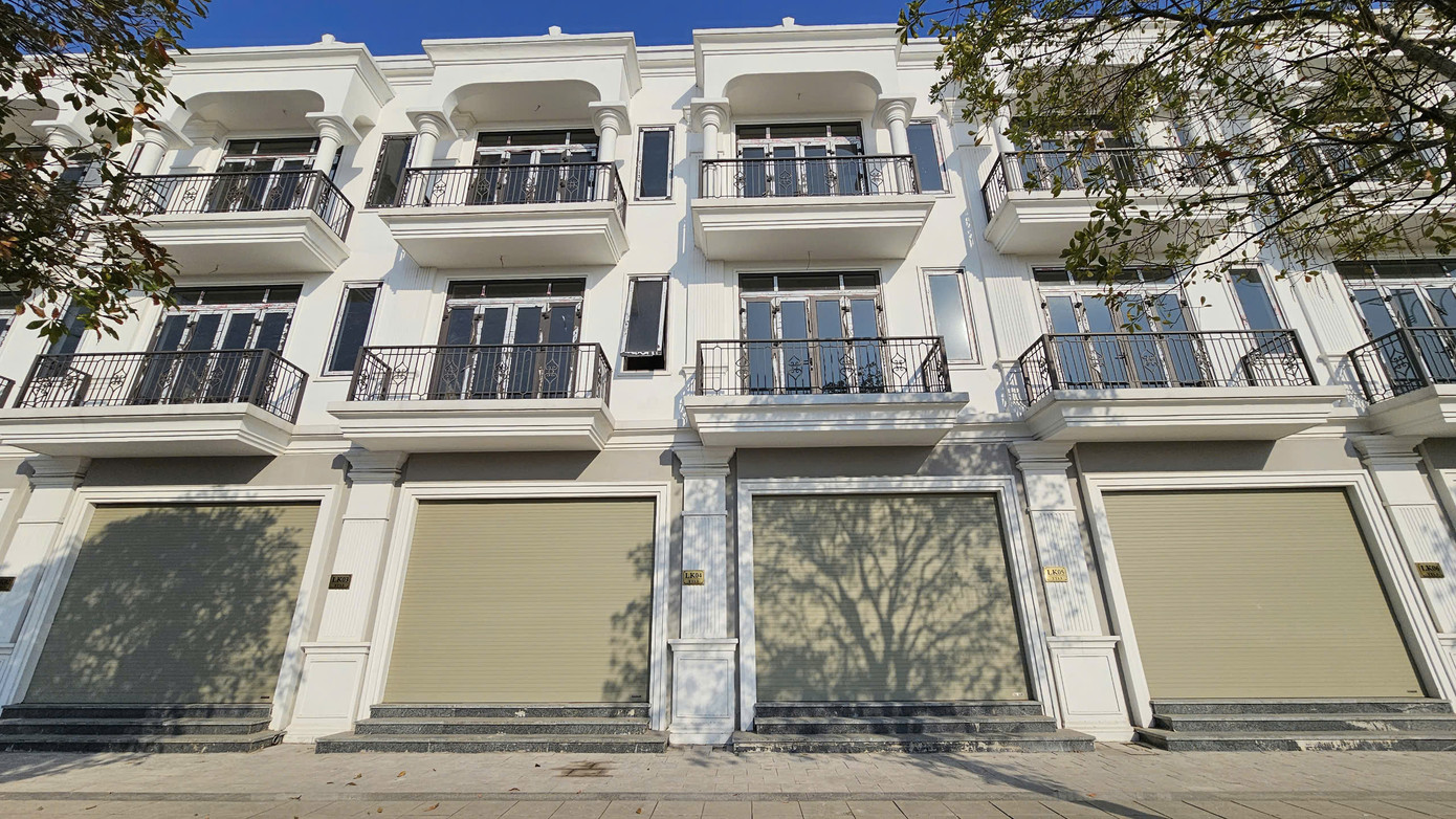 Theo ghi nhận của PV, nhiều căn liền kề, shophouse tại dự án Calyx Residence xã Uy Nỗ (huyện Đông Anh) vẫn trong tình trạng &quot;cửa đóng then cài&quot;. Các căn liền kề dự án này đang được rao bán trên thị trường với giá khoảng 140-150 triệu đồng/m2.