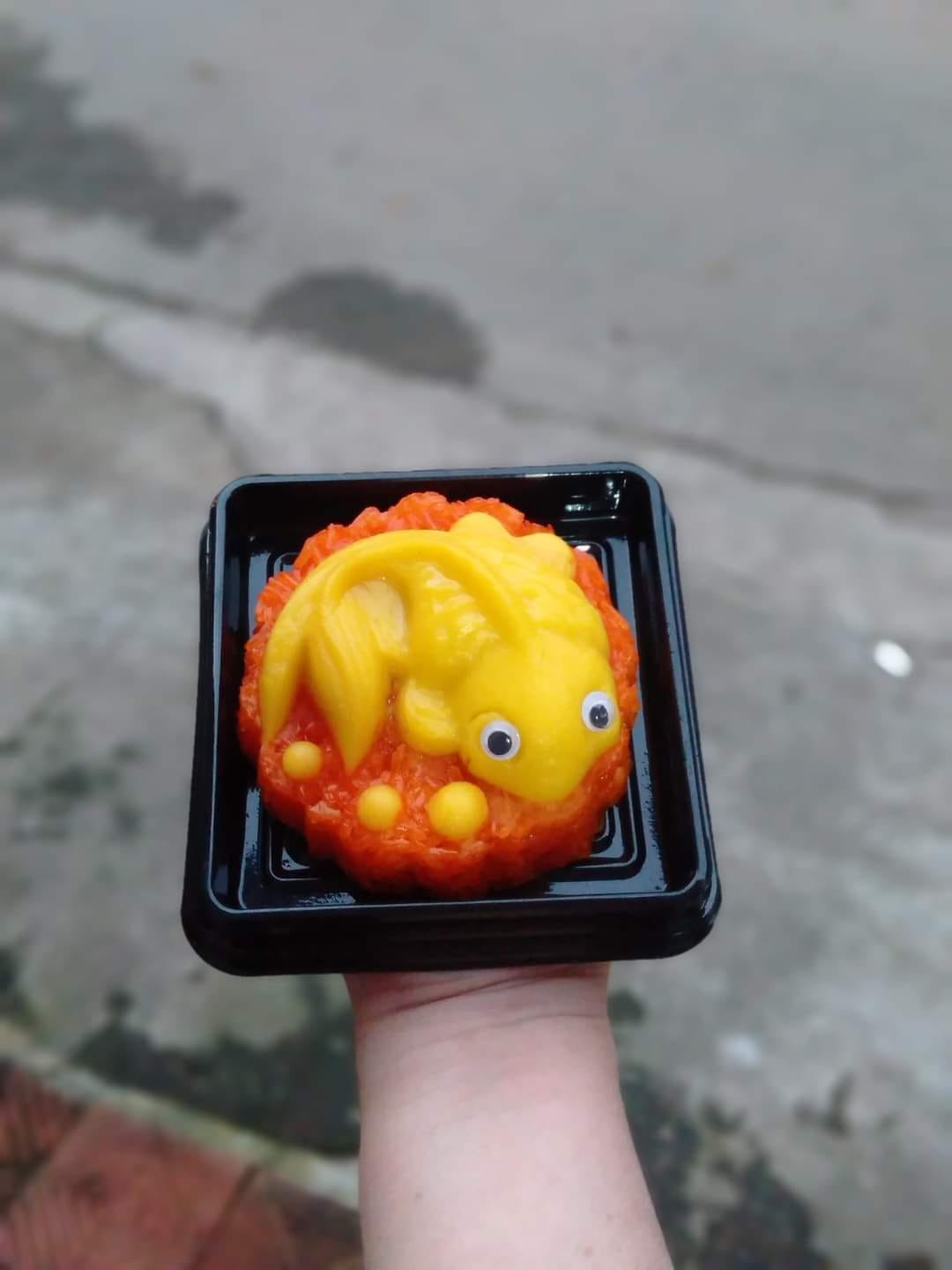 Cá chép được tạo hình bằng đậu xanh được sên mịn, đặt lên trên xôi gấc (Ảnh: Sony Nguyen) Cá chép được tạo hình bằng đậu xanh được sên mịn, đặt lên trên xôi gấc (Ảnh: Sony Nguyen)