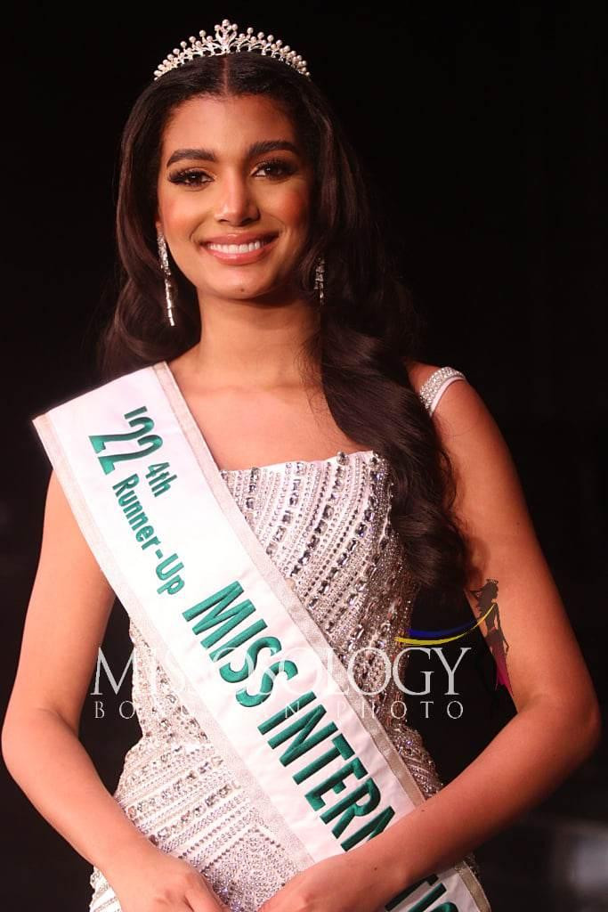 Á hậu 4 thuộc về người đẹp Cộng hòa Dominica - Celine Santos Frias. Cô diện bộ váy hai dây màu trắng với những chi tiết đính đá cầu kỳ dọc thân váy. Thiết kế thiên về phong cách ngọt ngào, không quá hở vòng 1.