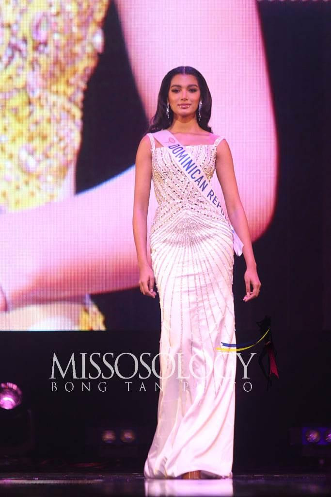 Á hậu 4 thuộc về người đẹp Cộng hòa Dominica - Celine Santos Frias. Cô diện bộ váy hai dây màu trắng với những chi tiết đính đá cầu kỳ dọc thân váy. Thiết kế thiên về phong cách ngọt ngào, không quá hở vòng 1.