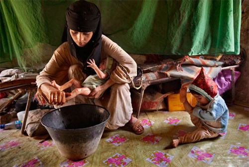 Bà mẹ 14 tuổi tắm cho con, bên cạnh là đứa con khác đã hai tuổi