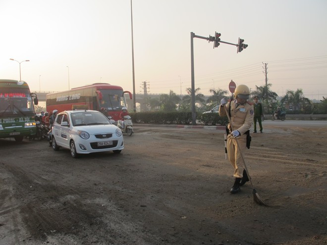 CSGT phủ cát lên dầu loang ở mặt đường. 