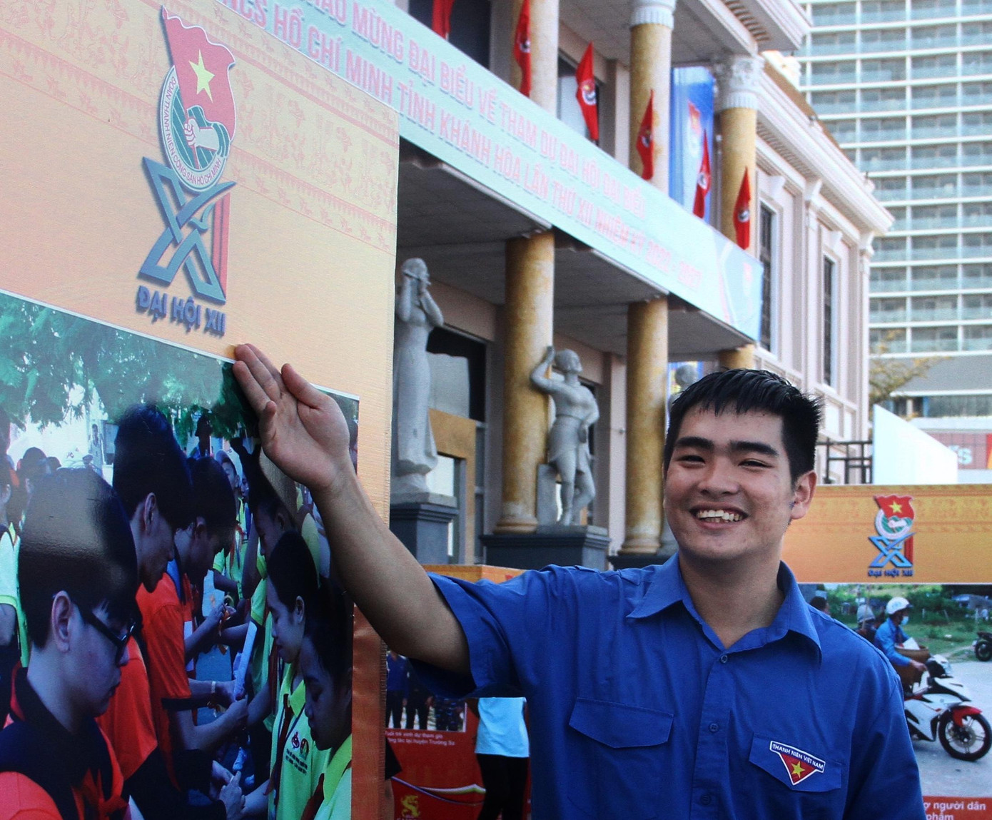 Anh Thái Trường Sơn vui mừng bên logo Đại hội tại triển lãm. Ảnh T.H