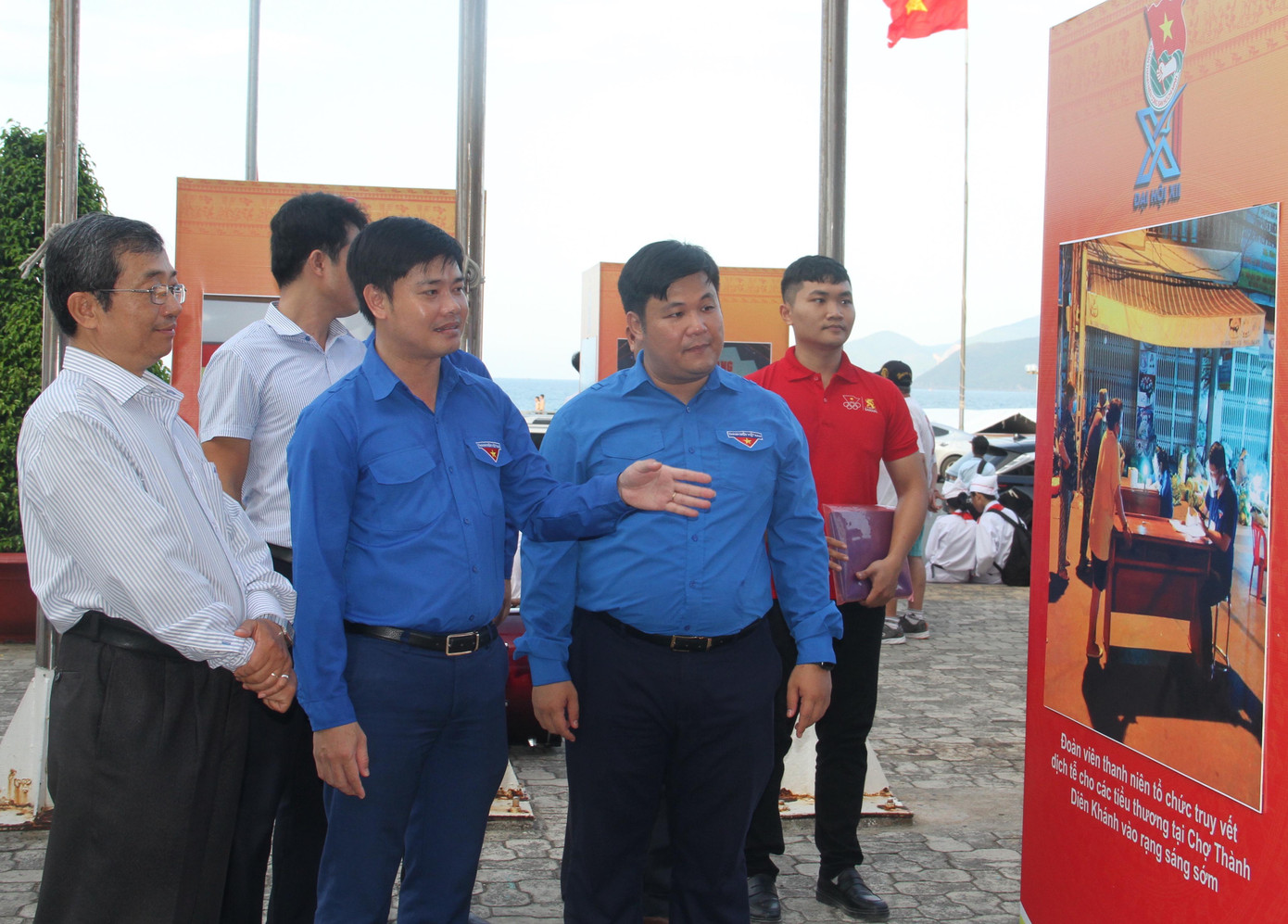 Anh Nguyễn Thái An và anh Bùi Hoài Nam (thứ 2 và thứ 3 từ phải qua) xem các bức ảnh tại triển lãm. Ảnh T.H