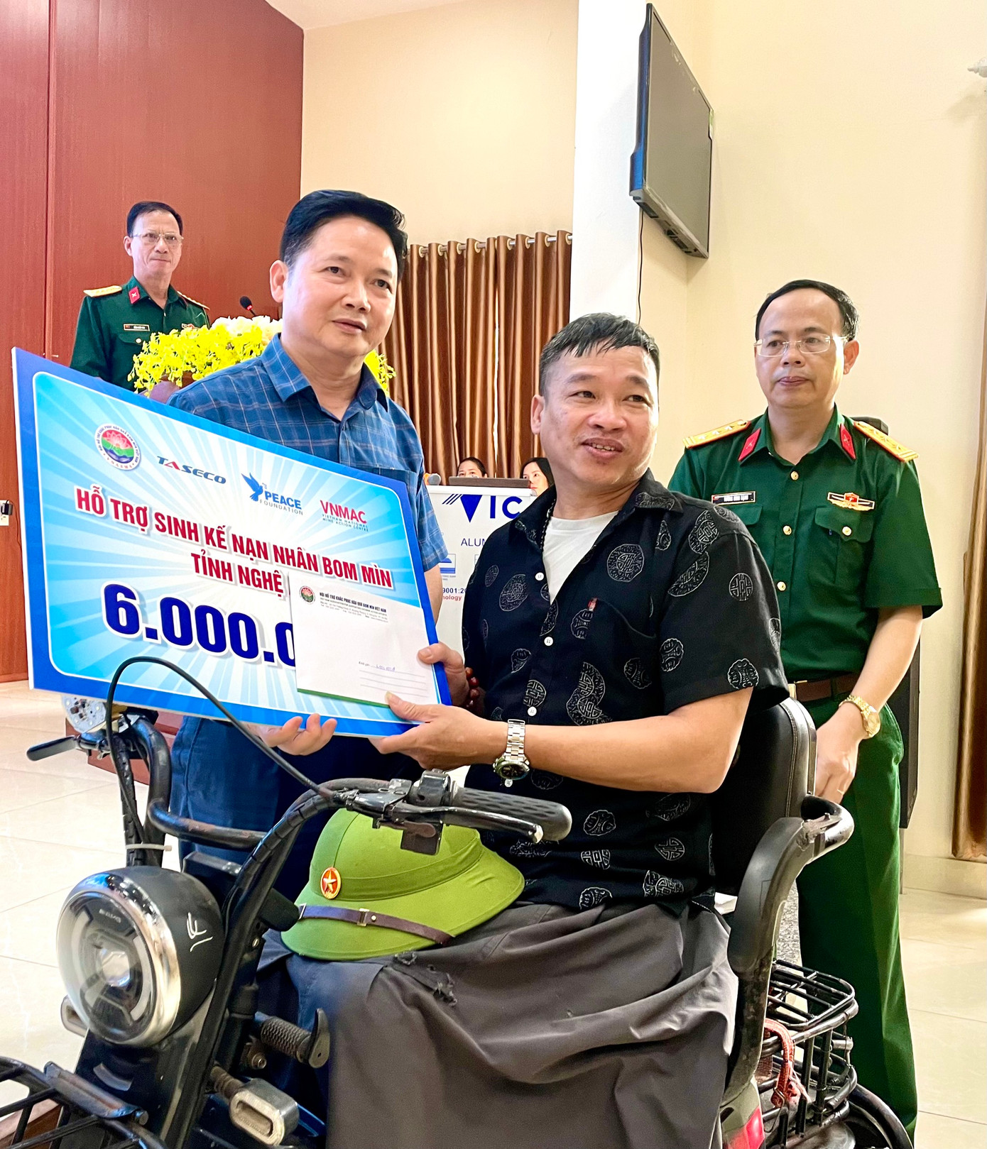 Ông Nguyễn Quang Huy - Phó Tổng Giám đốc TASECO, trao tặng hỗ trợ sinh kế cho một nạn nhân bom mìn tại huyện Nam Đàn.