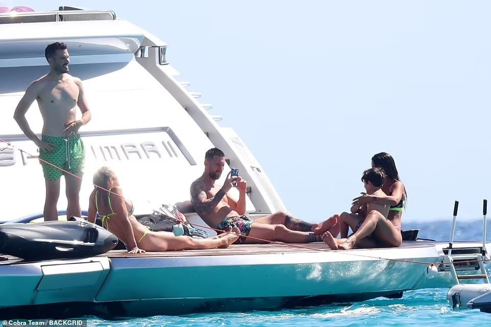 Luis và bà xã Sofia Balbi tắm nắng bên cạnh gia đình Messi đang chụp ảnh "sống ảo".