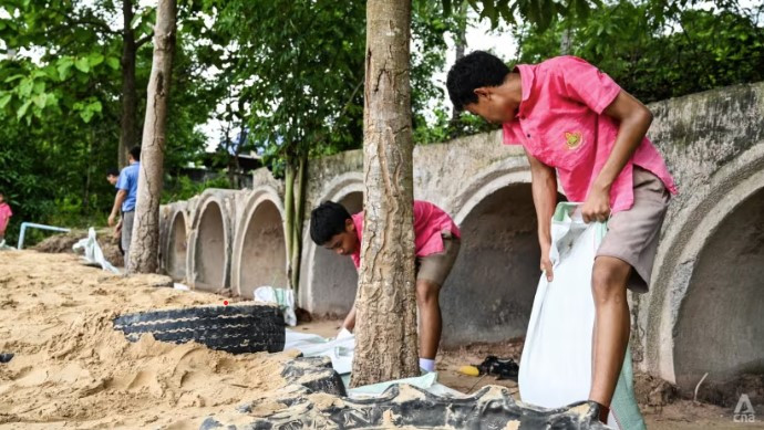 Các học sinh của Trường Ban Non Yang chuẩn bị hầm trú ẩn tránh bom. (Ảnh: CNA)