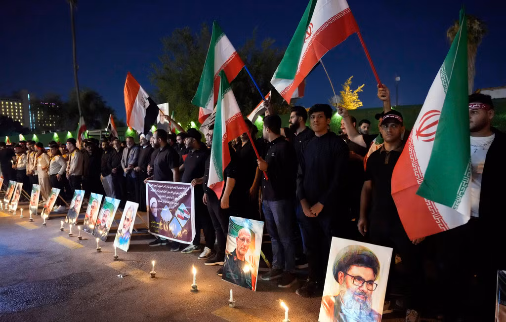 Ngày 28/6, nhiều người tập trung trước Đại sứ quán Iran tại Baghdad, Iraq, mang theo nến và cờ Iran để tưởng nhớ các tướng lĩnh quân đội Iran, nhà khoa học hạt nhân và các thành viên gia đình của họ đã thiệt mạng trong chiến dịch không kích của Israel. (Ảnh: AP)