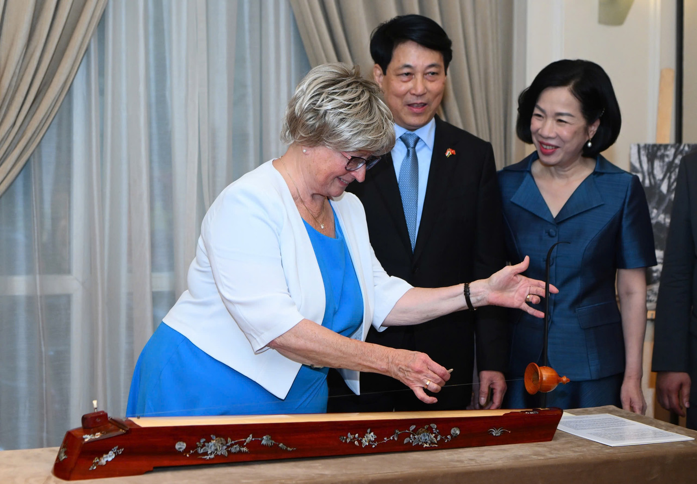 Phu nhân Nagy Zsuzsanna thử gảy đàn bầu. Ảnh: Nhật Minh Phu nhân Nagy Zsuzsanna thử gảy đàn bầu. Ảnh: Nhật Minh