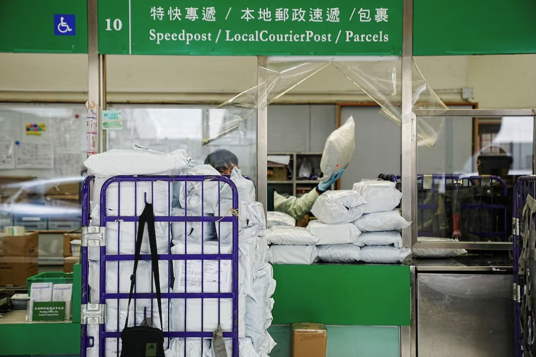 Một nhân viên bưu điện đang xử lý các gói hàng tại bưu điện ở Hong Kong, Trung Quốc, ngày 9/4. (Ảnh: Reuters)