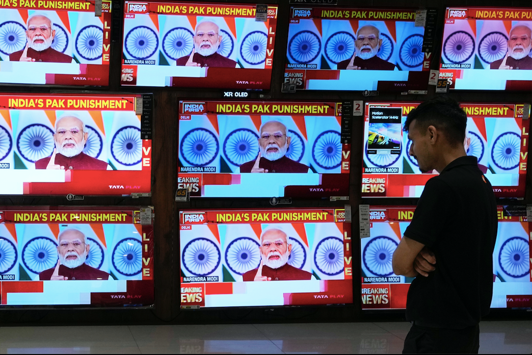 Một người ở Mumbai đang xem truyền hình trực tiếp bài phát biểu của Thủ tướng Ấn Độ Narendra Modi, ngày 12/5. (Ảnh: AP)