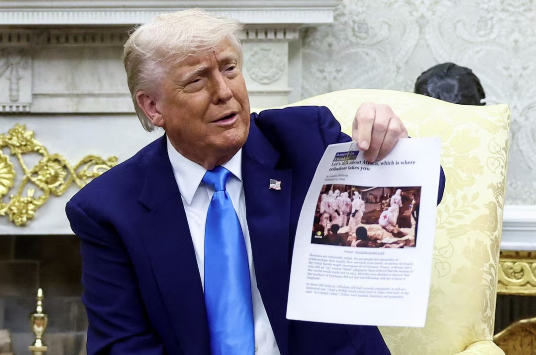 Tổng thống Mỹ Donald Trump giơ bài viết có hình ảnh vụ chôn tập thể ở CHDC Congo trong cuộc gặp Tổng thống Nam Phi. (Ảnh: Reuters) Tổng thống Mỹ Donald Trump giơ bài viết có hình ảnh vụ chôn tập thể ở CHDC Congo trong cuộc gặp Tổng thống Nam Phi. (Ảnh: Reuters)