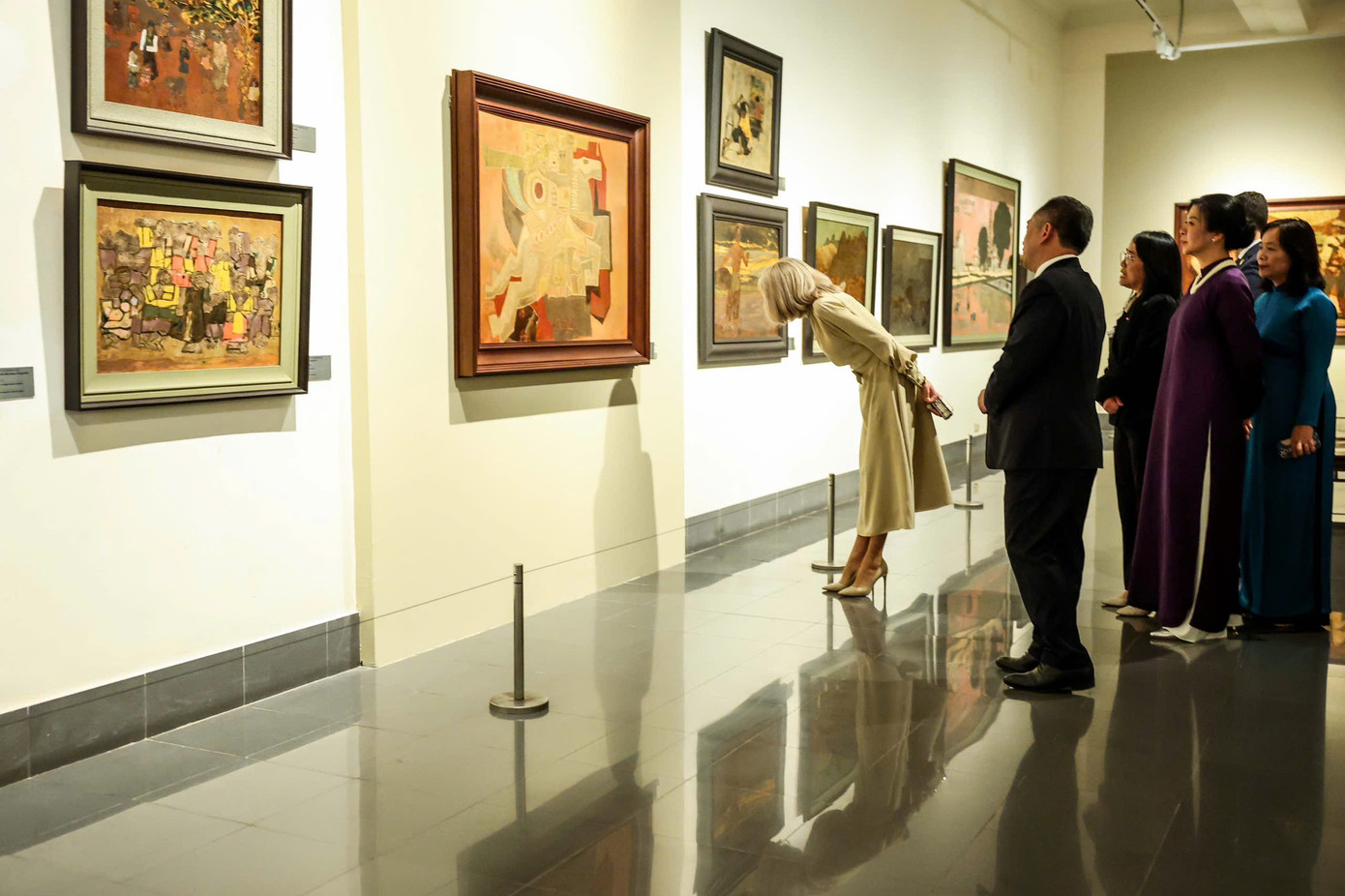 Phu nhân Brigitte Marie-Claude Macron chăm chú xem các tác phẩm hội hoạ. Ảnh: Nhật Minh