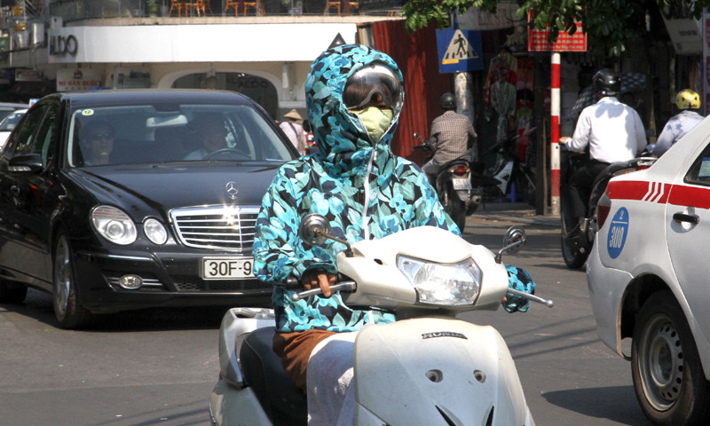 Nắng nóng gay gắt khiến người dân ra đường phải trùm kín người bằng khẩu trang, áo chống nắng, kính râm...