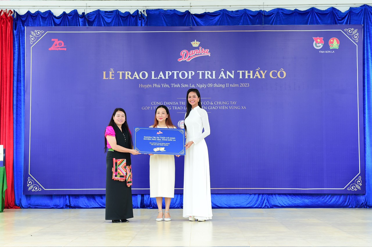 Hoa hậu H'Hen Niê và bà Phạm Thị Thu Thảo - Giám đốc Marketing nhãn hàng Danisa Việt Nam (ở giữa) trao tặng biểu trưng cho đại diện Phòng Giáo dục huyện Phù Yên, tỉnh Sơn La.