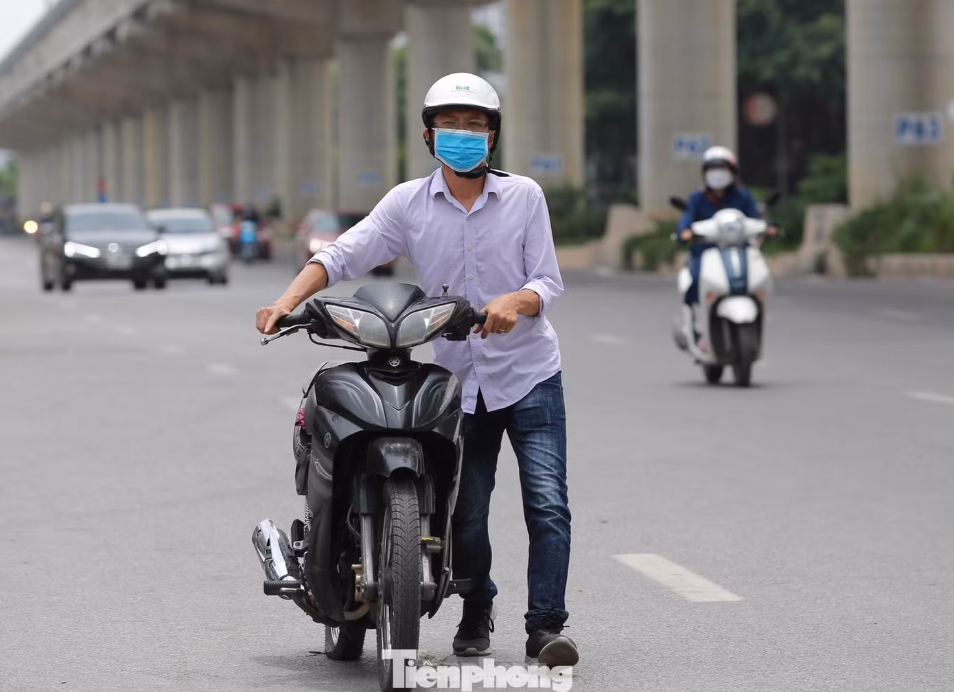 Người đi đường khổ sở sau khi xe bị bục lốp dưới trời thời tiết nắng nóng đỉnh điểm.