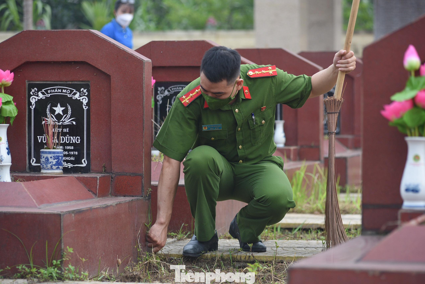 Đoàn viên thanh niên công an Thủ đô dọn dẹp, nhổ cỏ quanh mộ liệt sĩ.