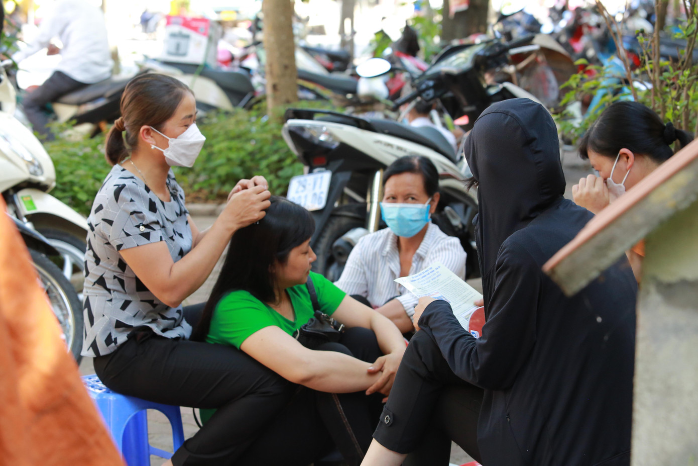 Nhóm phụ huynh tạm dừng công việc đồng áng để đợi con thi.