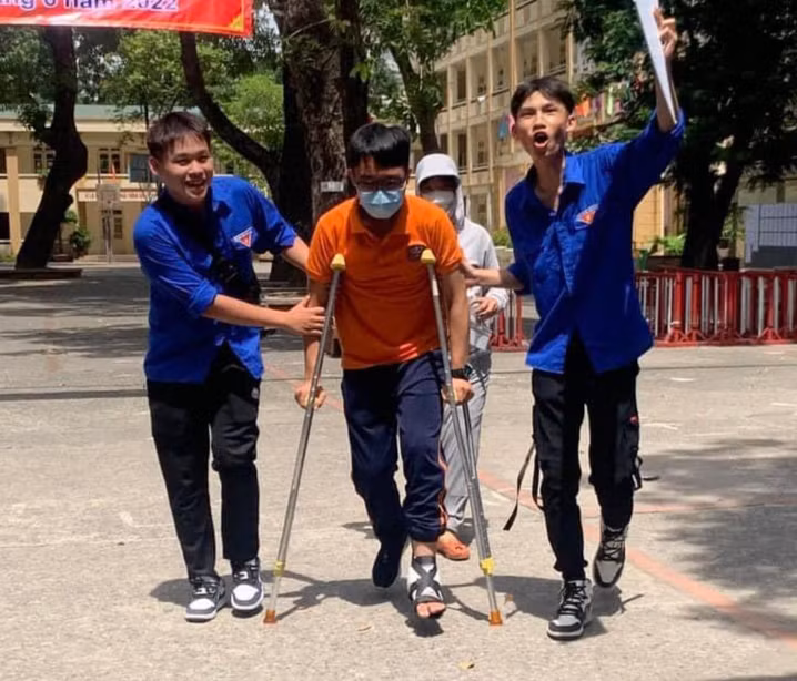 Tình nguyện viên giúp đỡ sĩ tử bị thương trong quá trình di chuyển đến phòng thi. Ảnh: Thành Đoàn Hà Nội.