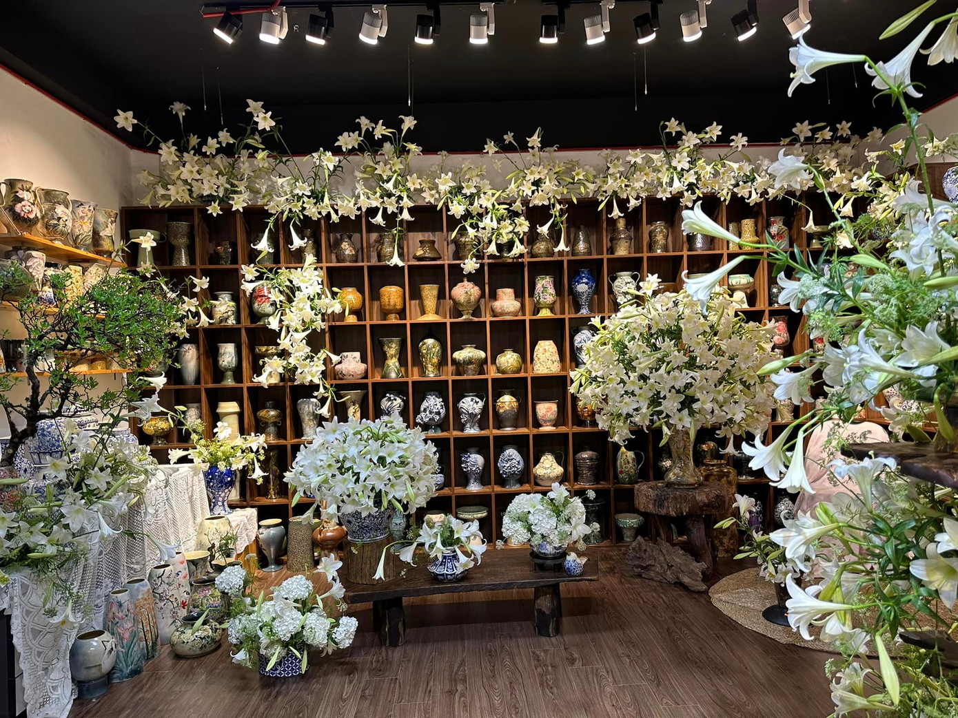 Phòng gốm của Trang nổi bật hơn khi sắc trắng tinh khôi của hoa loa kèn tháng Tư làm tôn lên màu trầm của gỗ, màu lam của gốm. Trang cho biết, cô và nhóm bạn đều có sở thích chơi hoa nên đã có ý tưởng ngẫu hứng về một phòng hoa loa kèn. Tổng thời gian nhóm bạn cắm hoa mất gần 4 tiếng và không tham khảo thiết kế có trước. "Hoa mình đã dưỡng nở rồi mới cắm lên nên sau khi cắm thì đã có một vườn hoa rực rỡ", Trang nói.