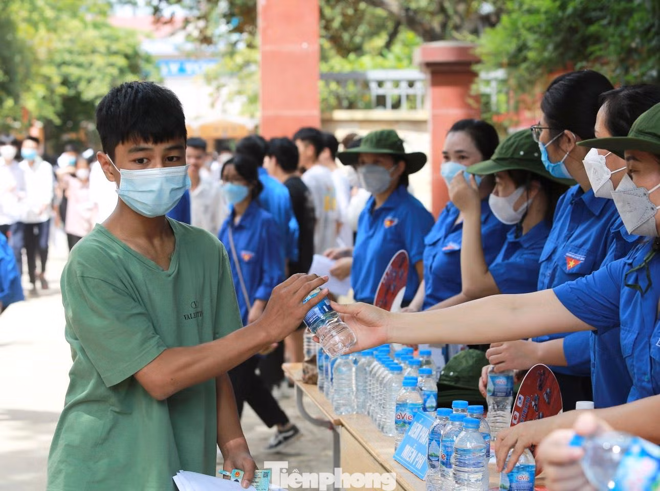 Tình nguyện viên phát nước miễn phí, tặng quạt cầm tay, hướng dẫn thí sinh di chuyển... ngoài cổng điểm thi.