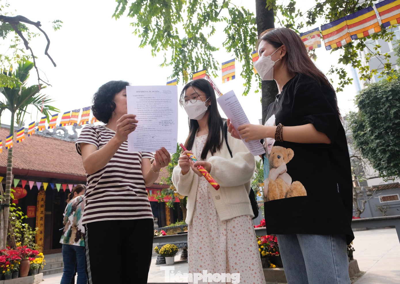 Hai bạn trẻ đang được chỉ dẫn khấn theo &quot;văn mẫu&quot;.