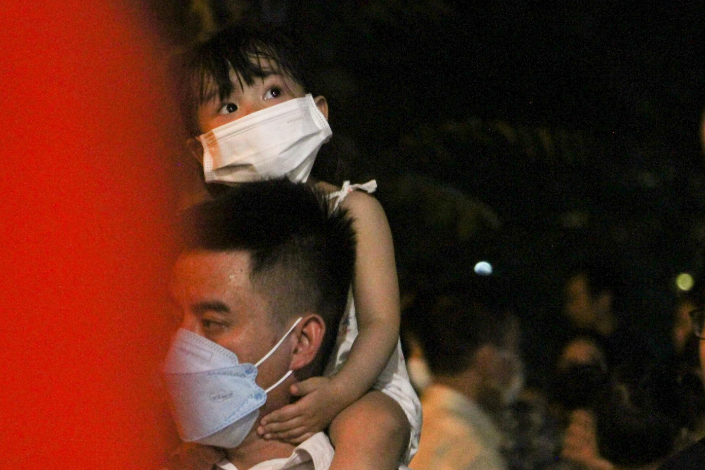 Các em nhỏ thường được bố mẹ cõng lên cổ để dễ dàng di chuyển trong không gian chật kín người.