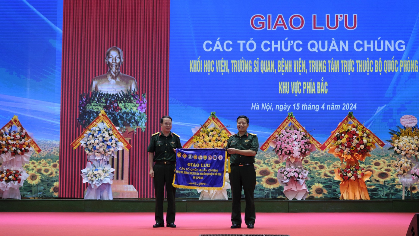 Đại tá Nguyễn Quang Đông - Phó Chủ nhiệm Chính trị Trường Sĩ quan Lục quân 1 trao cờ cho đơn vị đăng cai tổ chức tiếp theo. Ảnh: Châu Linh