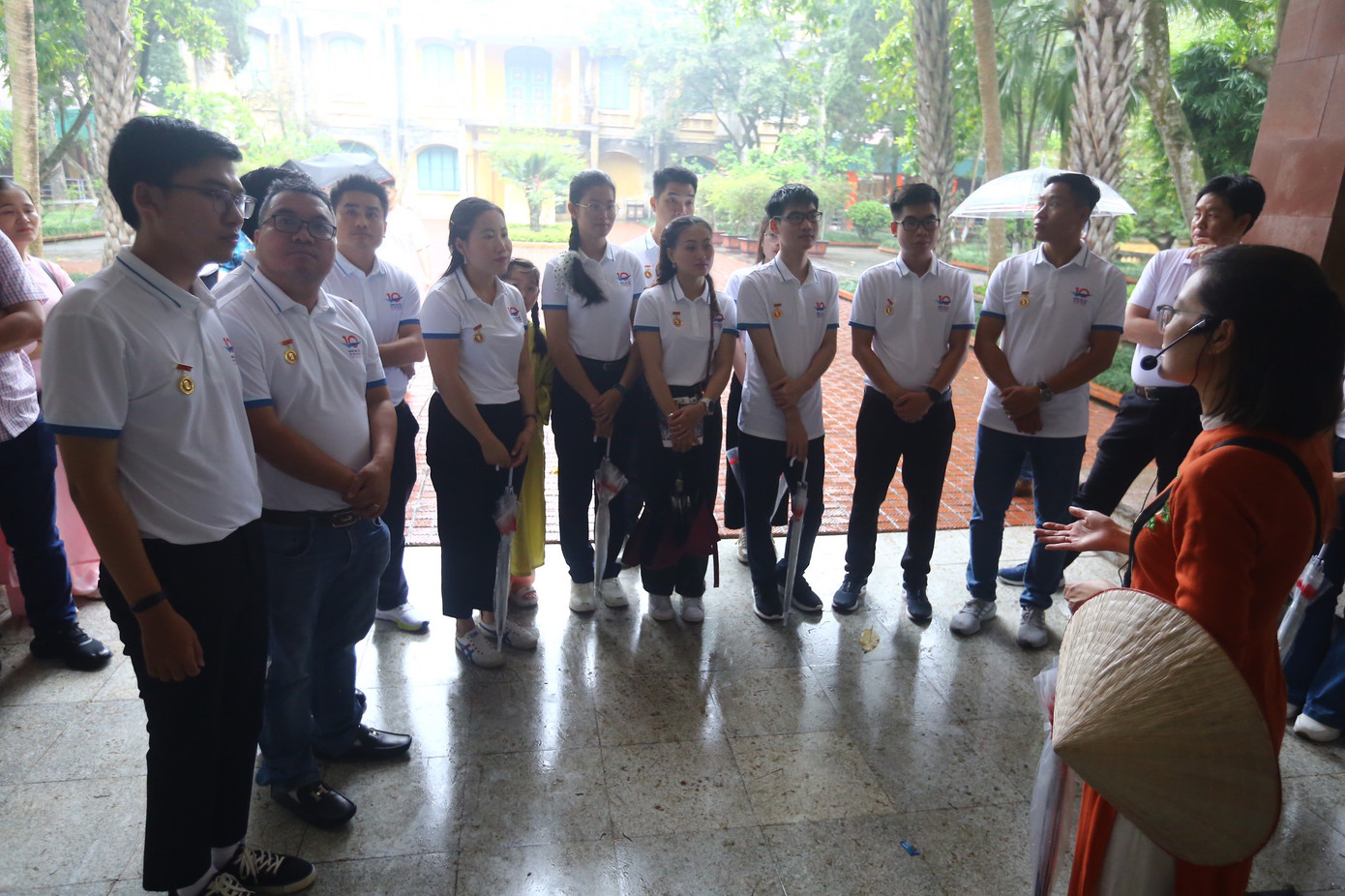 Các gương mặt trẻ chăm chú lắng nghe thuyết minh viên khi tham quan Hoàng thành Thăng Long.