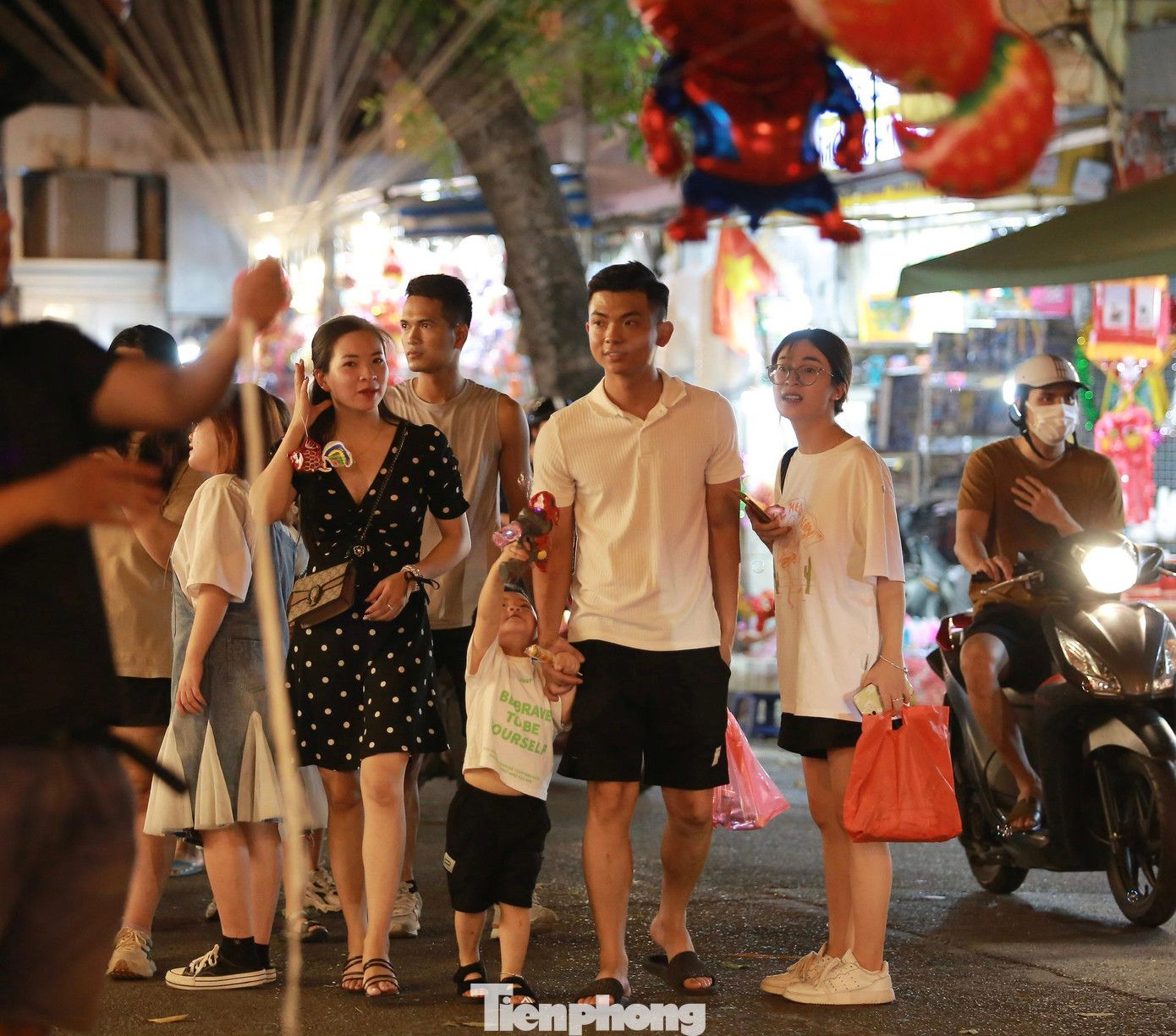 Các em nhỏ được bố mẹ đưa đi chơi tại phố Hàng Mã.