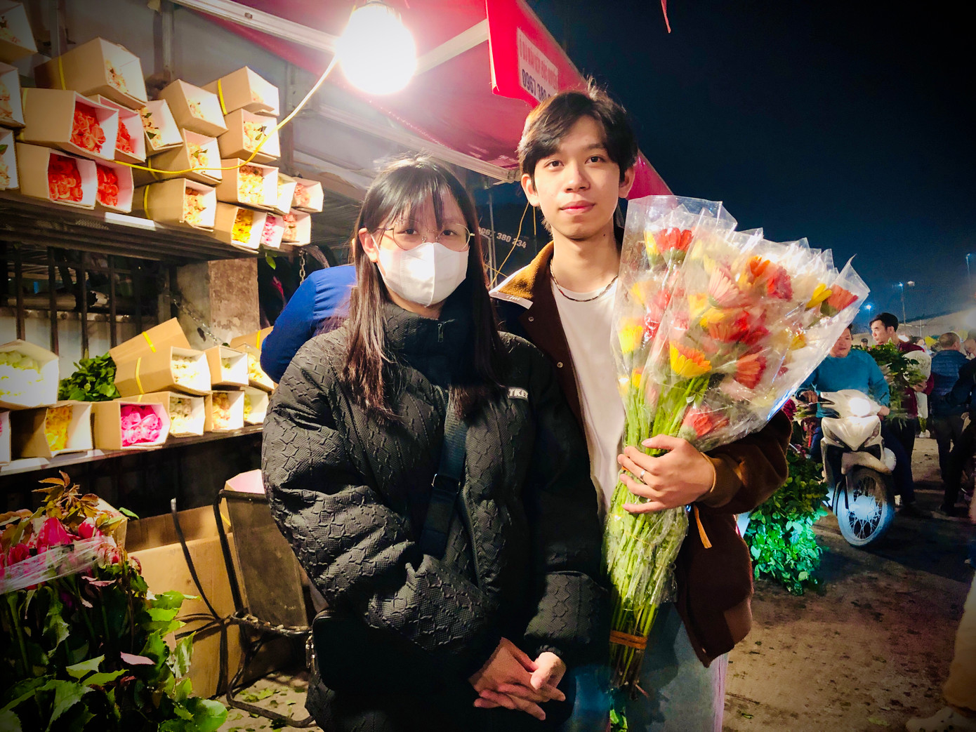 Chợ hoa Quảng An còn được biết đến là địa điểm hẹn hò lý tưởng của nhiều cặp đôi. Đến đây, các bạn nam thường mua tặng cho nửa kia của mình những bó hoa rực rỡ nhất để thể hiện tình cảm. Trong ảnh là bạn Tuấn Anh (21 tuổi) năm nay đi cùng người yêu để lựa chọn những bó hoa yêu thích trước ngày 8/3 và còn bật mí sẽ tạo một bất ngờ lớn trong ngày lễ đặc biệt dành tặng người mình yêu thương. Ảnh: Ngọc Hân