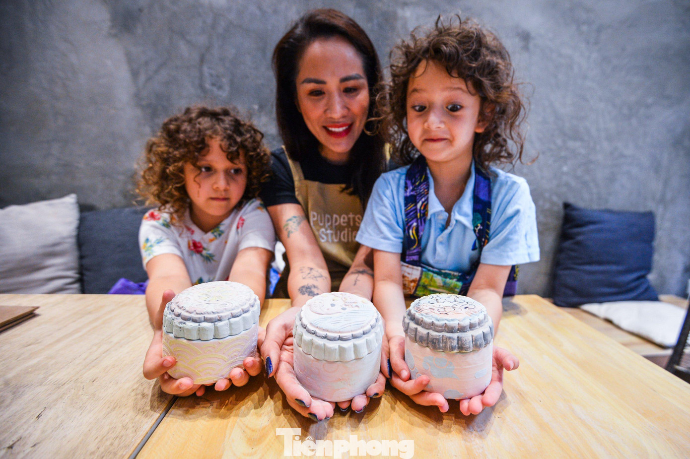 Chị Mai cùng hai cô con gái thích thú sau khi hoàn thiện sản phẩm hộp bánh bằng gốm.