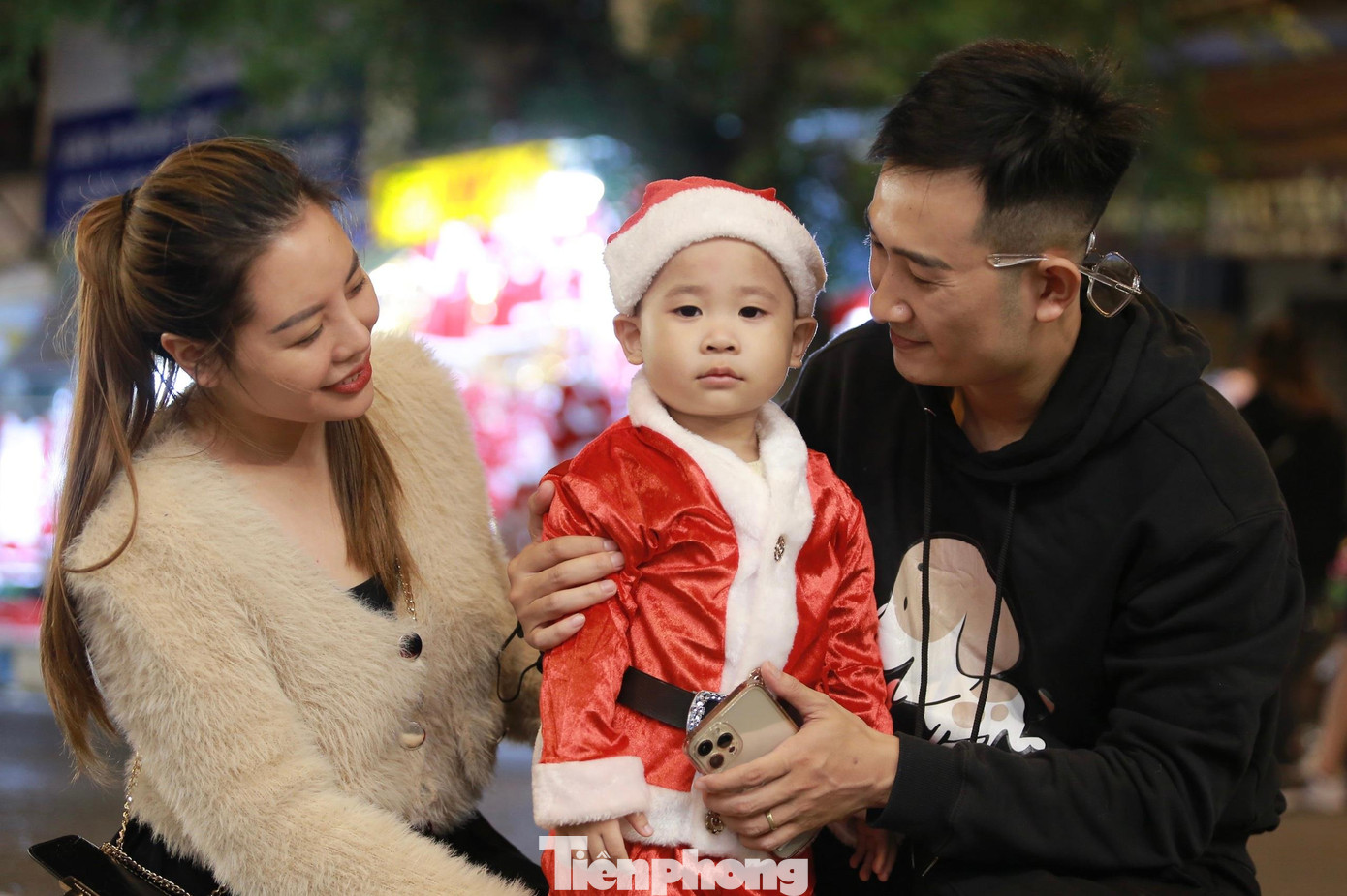 Gia đình trẻ cho con mặc trang phục ông già Noel xuống phố Gia đình trẻ cho con mặc trang phục ông già Noel xuống phố