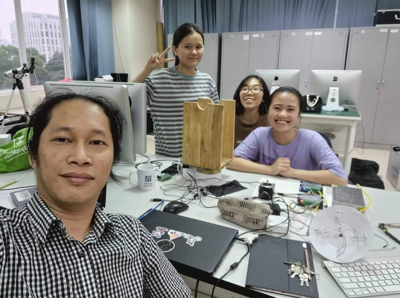 Linh chụp cùng thầy hướng dẫn và các bạn trong nhóm dự án về kính thiên văn.